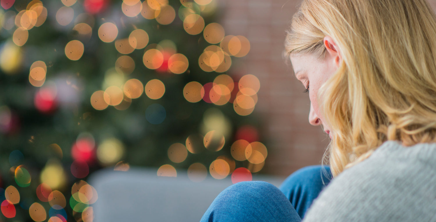 woman sad sitting near christmas tree