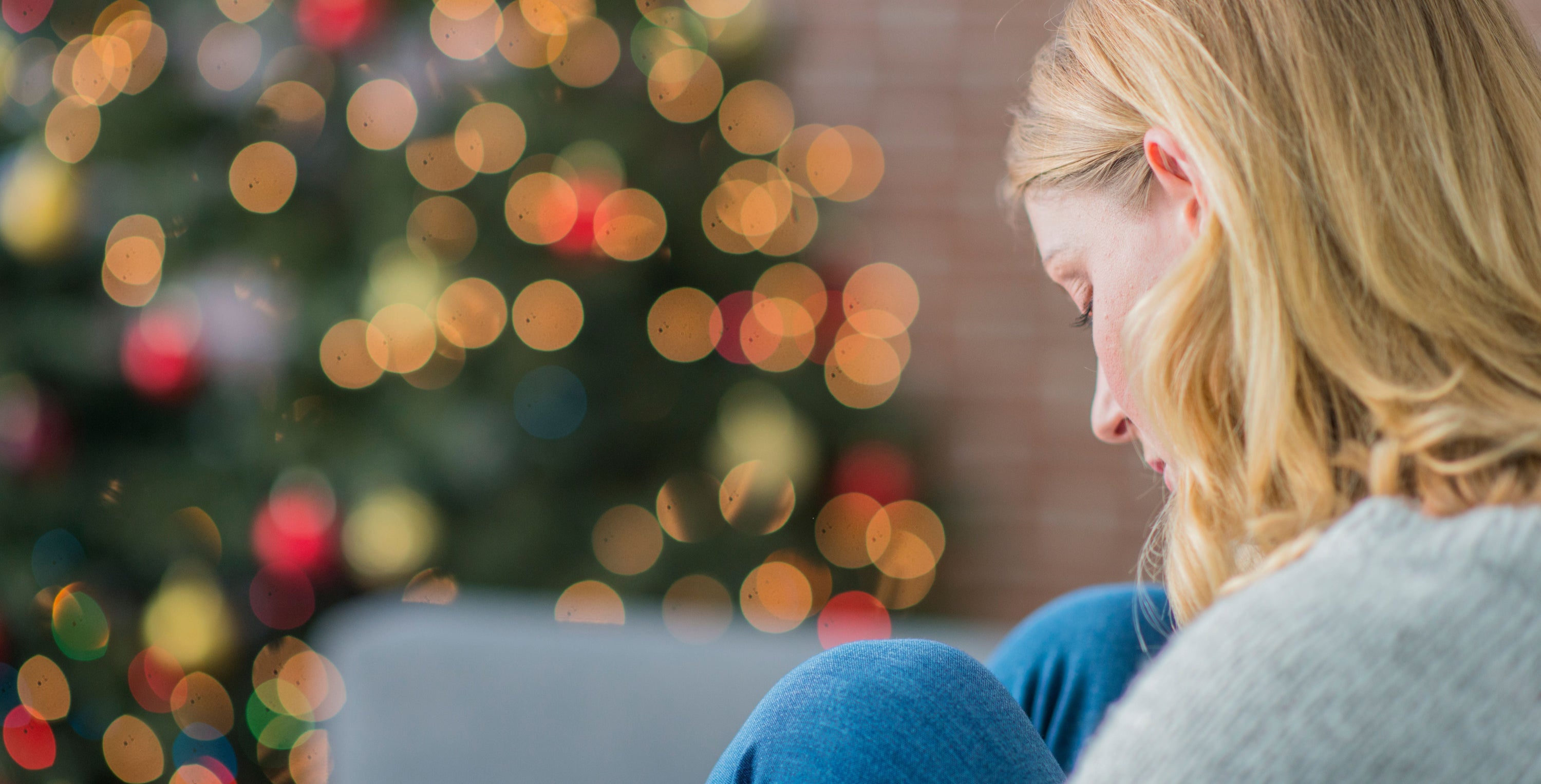 woman sad sitting near christmas tree