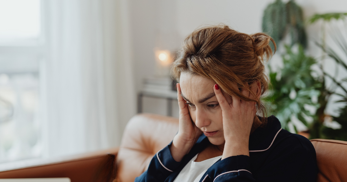 woman overwhelmed with her hands on her head